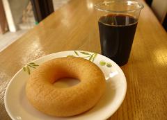 店内のテーブルに置かれたドーナツとコーヒーの写真