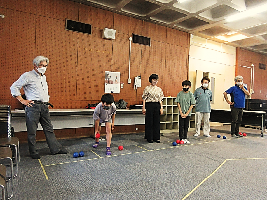 6つのスローイングボックスに立つプレイヤーと赤ボールを投げようとする男の子
