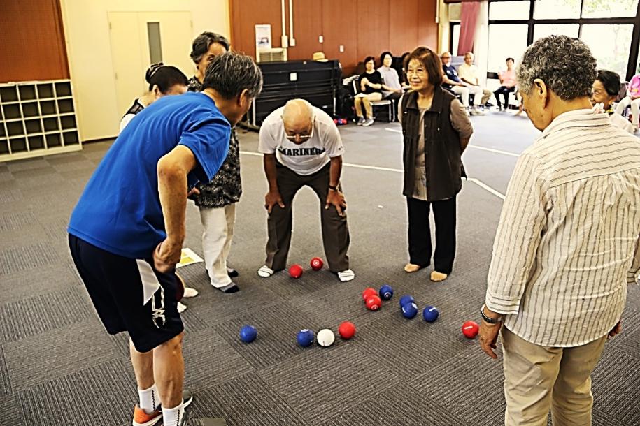 青球と赤球のどちらがジャックボールに近いか確認する参加者たち