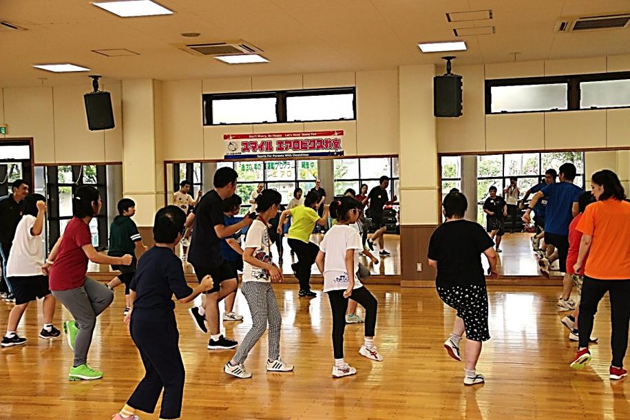 音楽に合わせて同じ動きをとる参加者たち