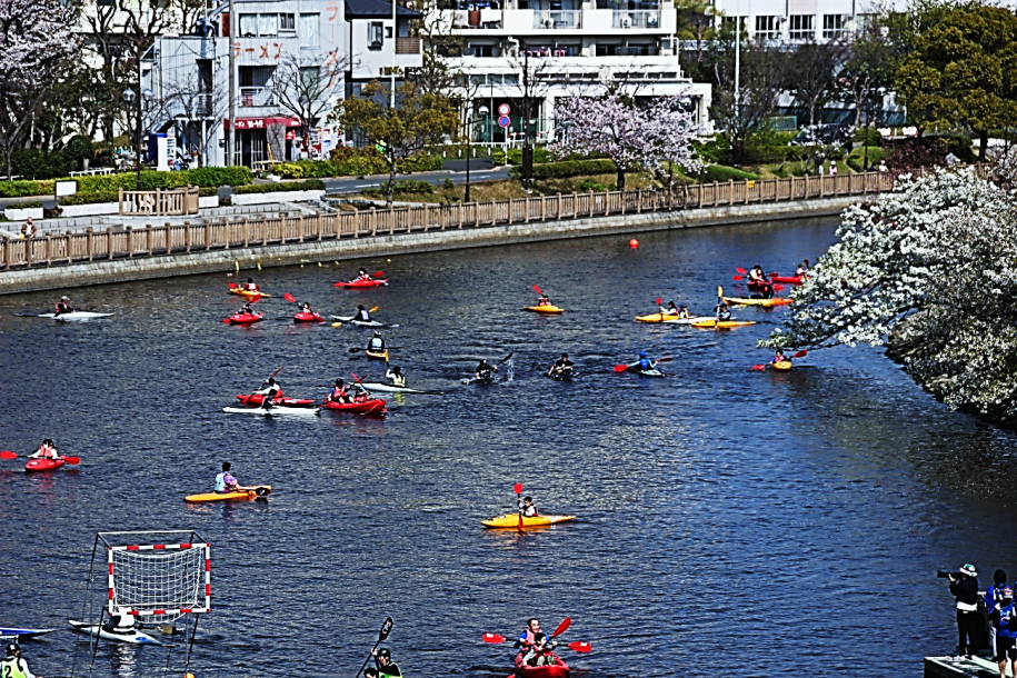 春に桜を見ながらカヌーを楽しむ人達