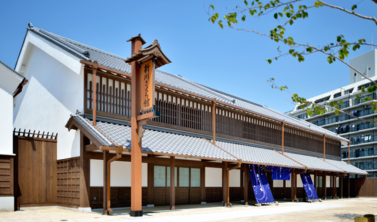 画像新川さくら館全景です。江戸時代の街並みをイメージする瓦屋根の純木造建築です。