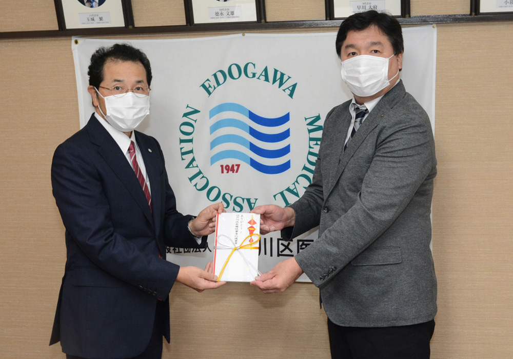 写真：江戸川区医師会の田部会長へ応援金をお渡しする様子