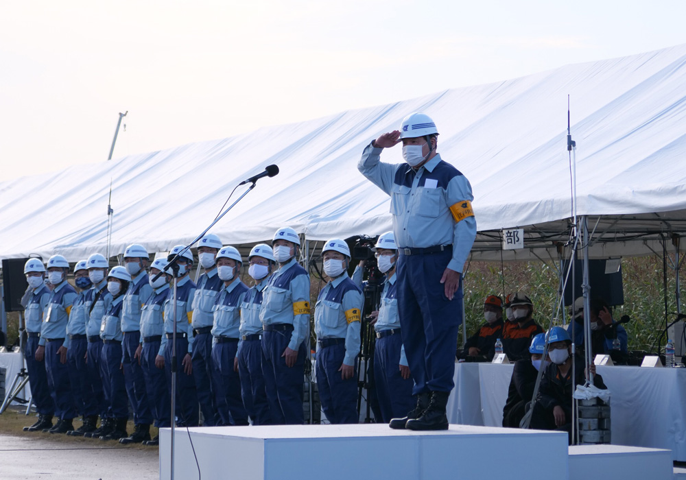 写真：壇上で敬礼する斉藤区長