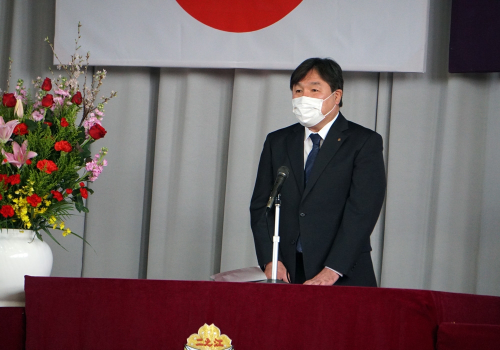 写真：壇上で挨拶する斉藤区長