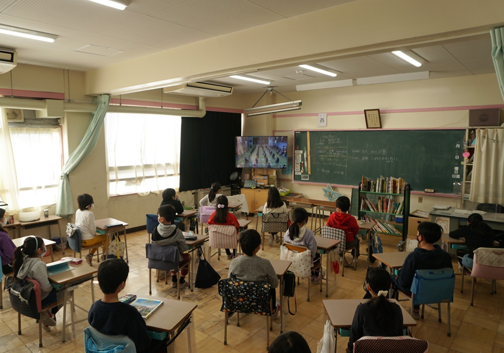 写真：教室で式典のオンライン配信を見守る児童たち