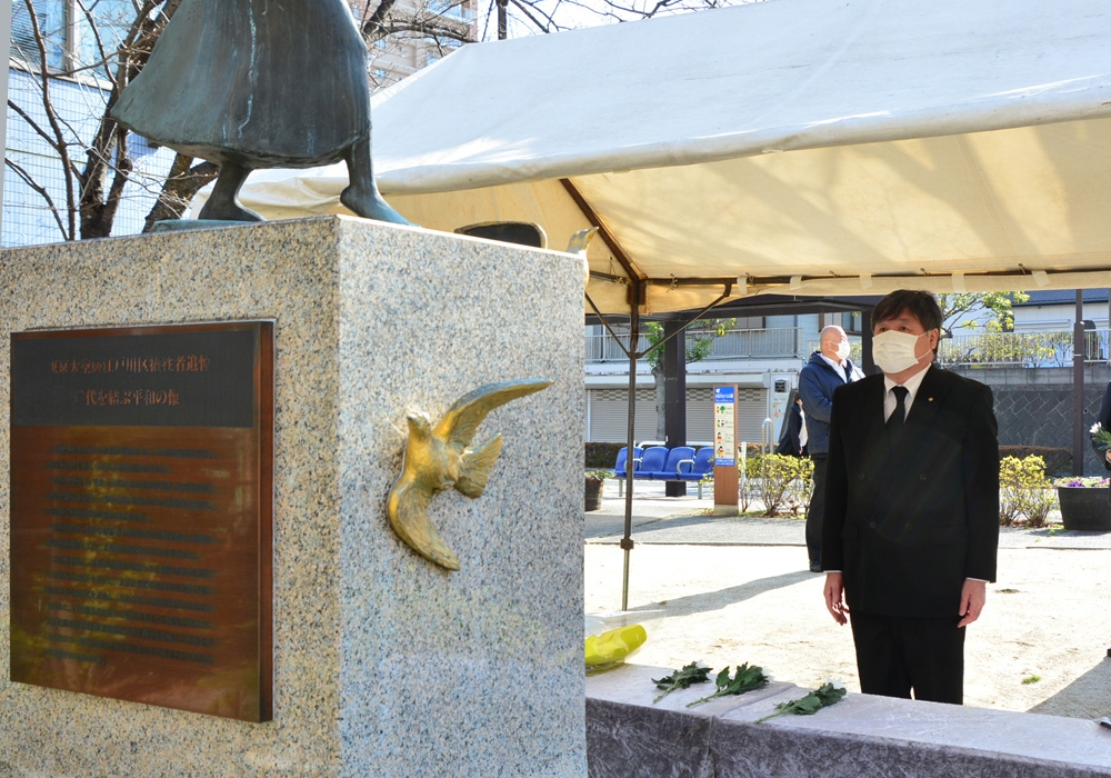写真：「世代を結ぶ平和の像」に祈る斉藤区長