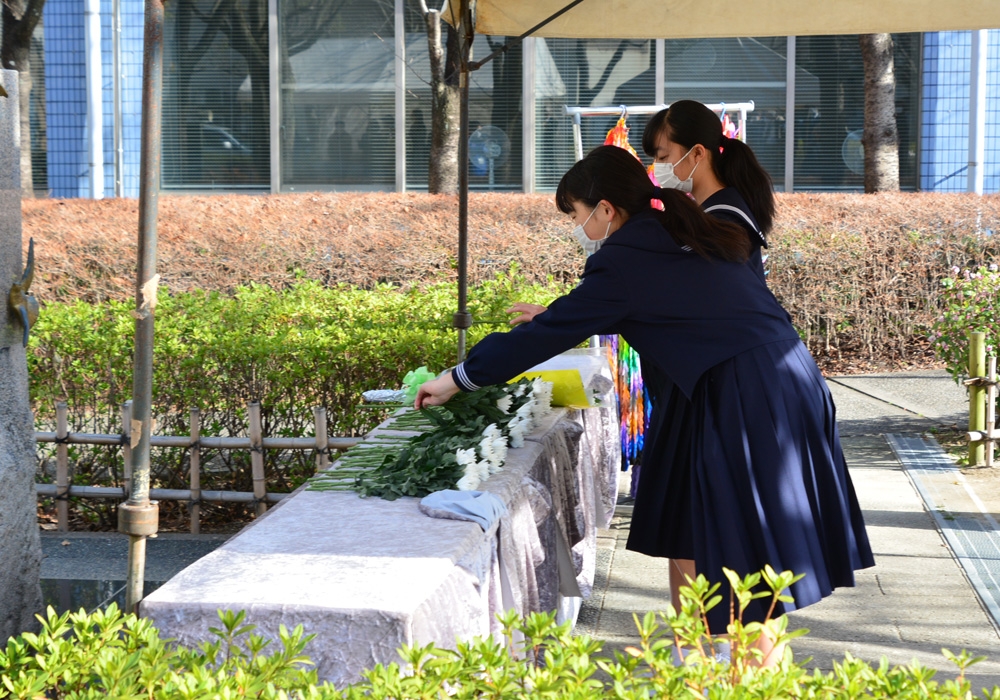 写真：献花台に献花する地元中学校の生徒の様子