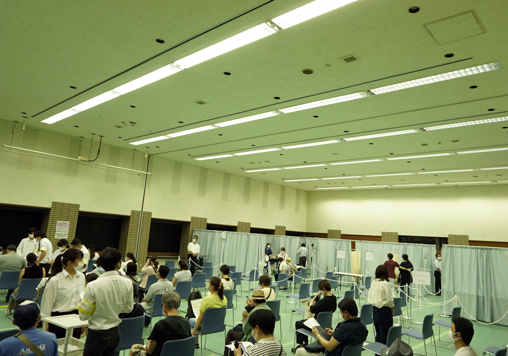 接種会場で接種を待つ人々