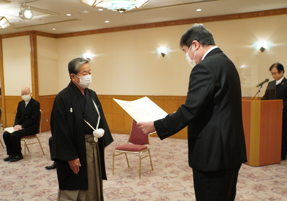 写真：盆栽作家の小林國雄さんに賞状を授与する斉藤区長