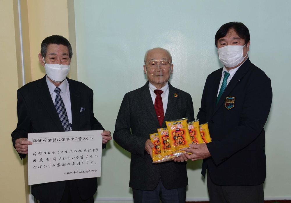 写真：小松川平井地区連合町会長たちからカイロを受け取る斉藤区長