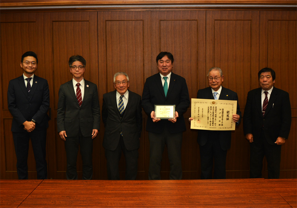 写真：認定証を手に、篠田堀親水緑道を愛する会の皆さんと斉藤区長