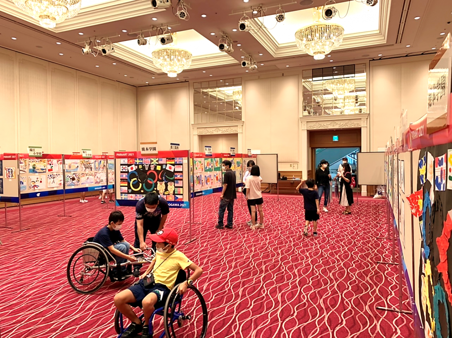 競技用車いすを体験する子どもと作品展示会