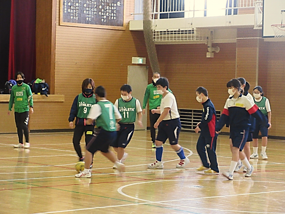 体育館内でサッカーをする参加者たち