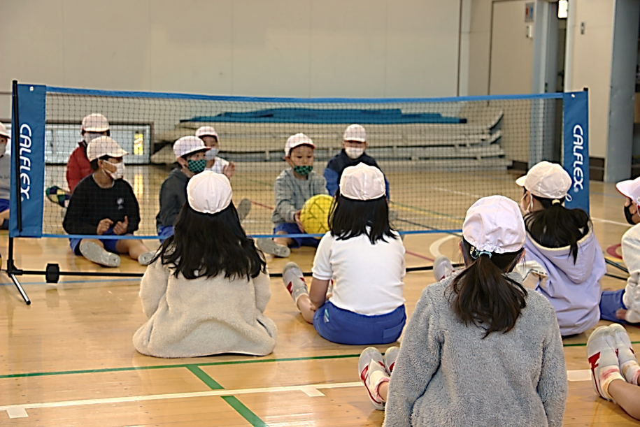 シッティングバレーボールの体験をする小学生