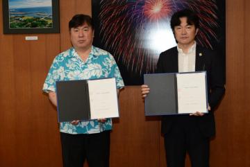 協定書を取り交わす斉藤区長（左）と清水代表（右）