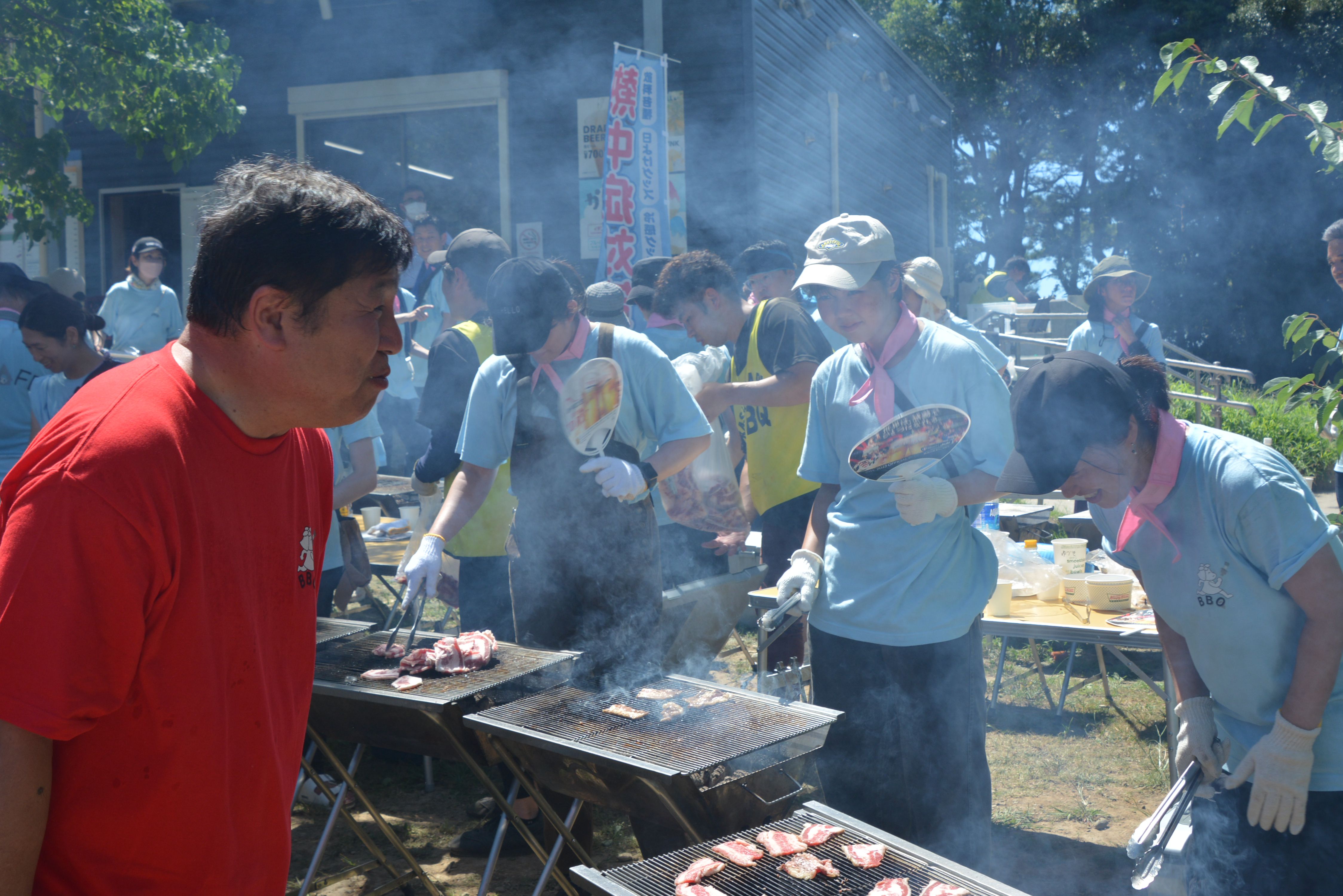 肉を焼くスタッフに声掛けをする斉藤区長