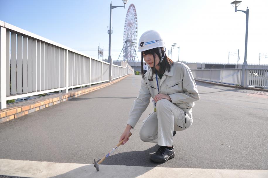 ハンマーを用いて橋梁を点検している様子