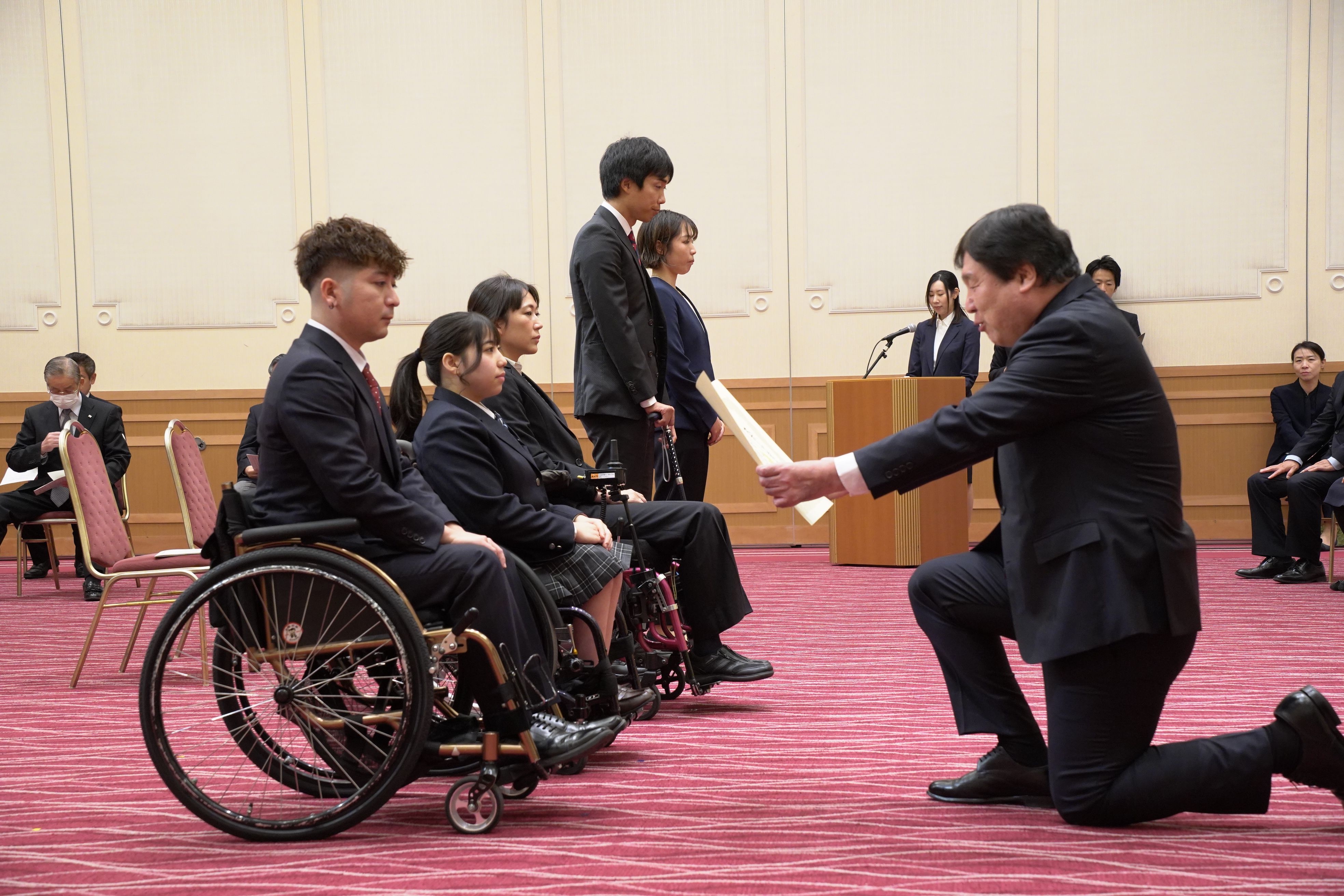 車いすのアスリートに賞状を授与する斉藤区長