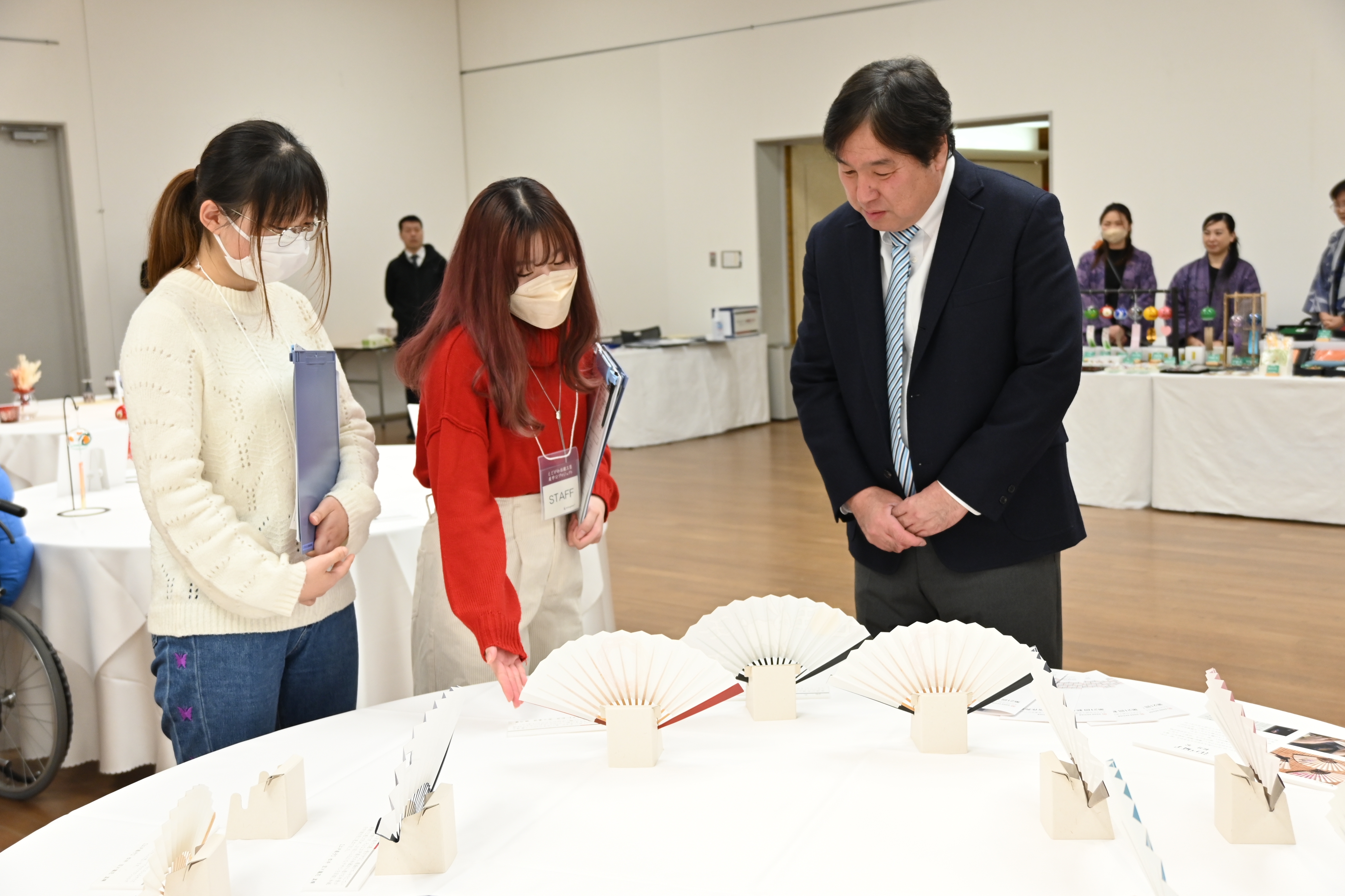 学生から江戸扇子の説明を受ける区長