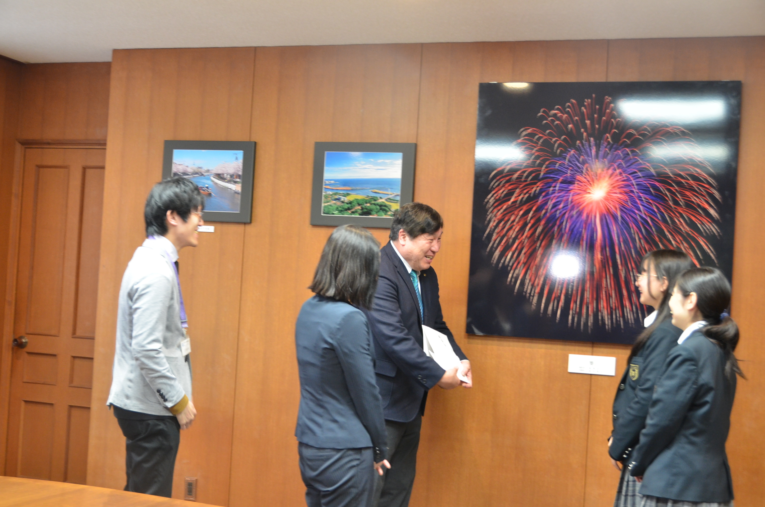義援金を受け取って会話をする斉藤区長とかるた部部員