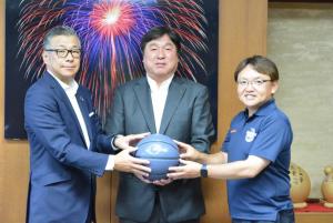三辰精工株式会社の本間さんらとバスケットボールを持って撮影する区長