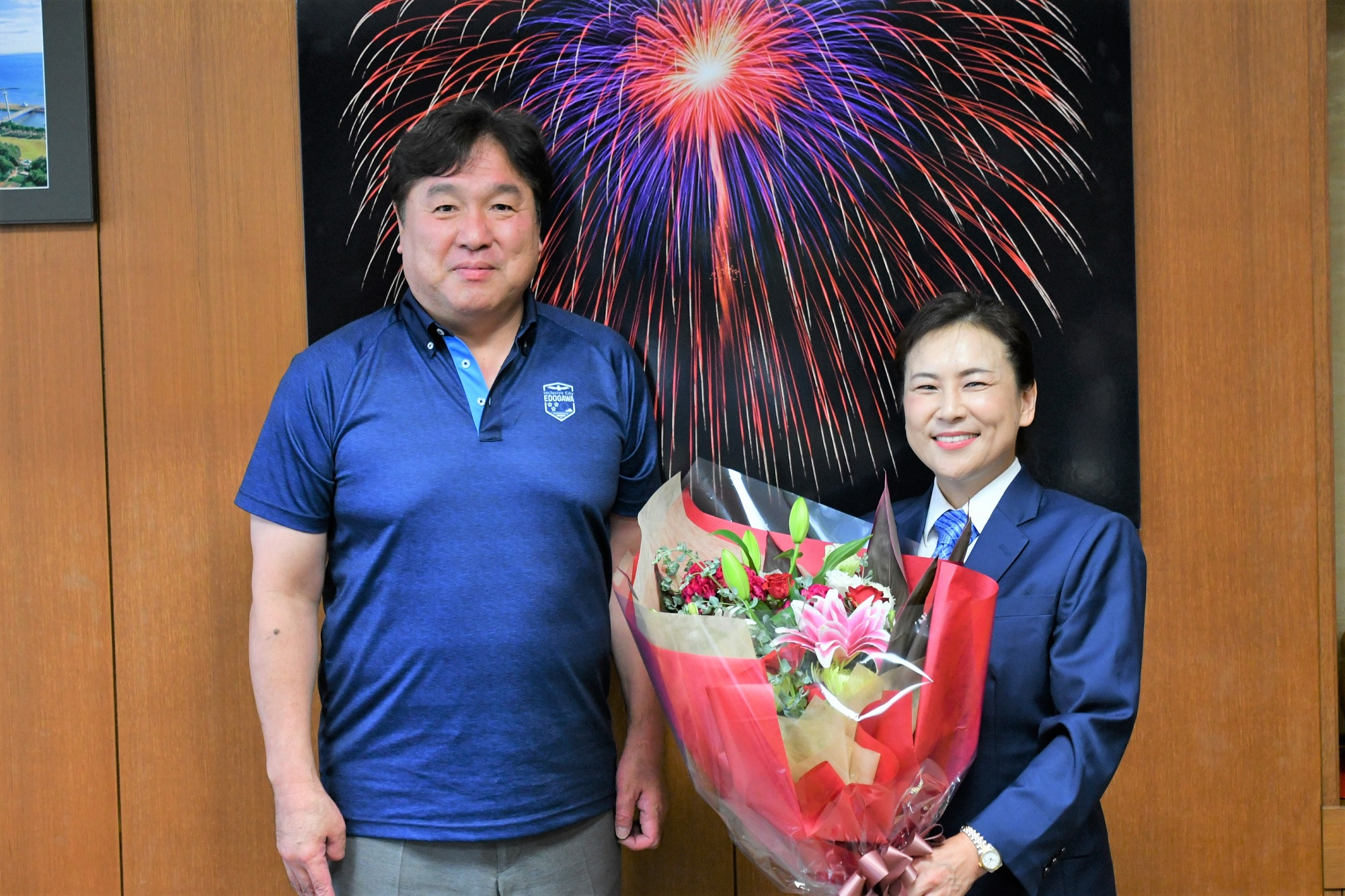 花束を抱えて微笑む天野さんと区長