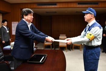 出発式で職員に発令通知書を手渡す区長