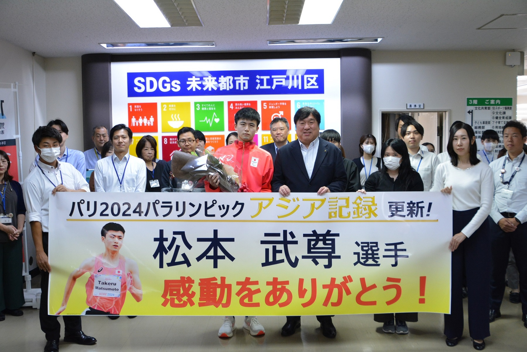 松本武尊選手と区長および区職員の集合写真