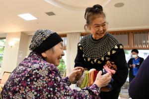 靴下カバーを特別養護老人ホームの入居者へ手渡す吉田さん
