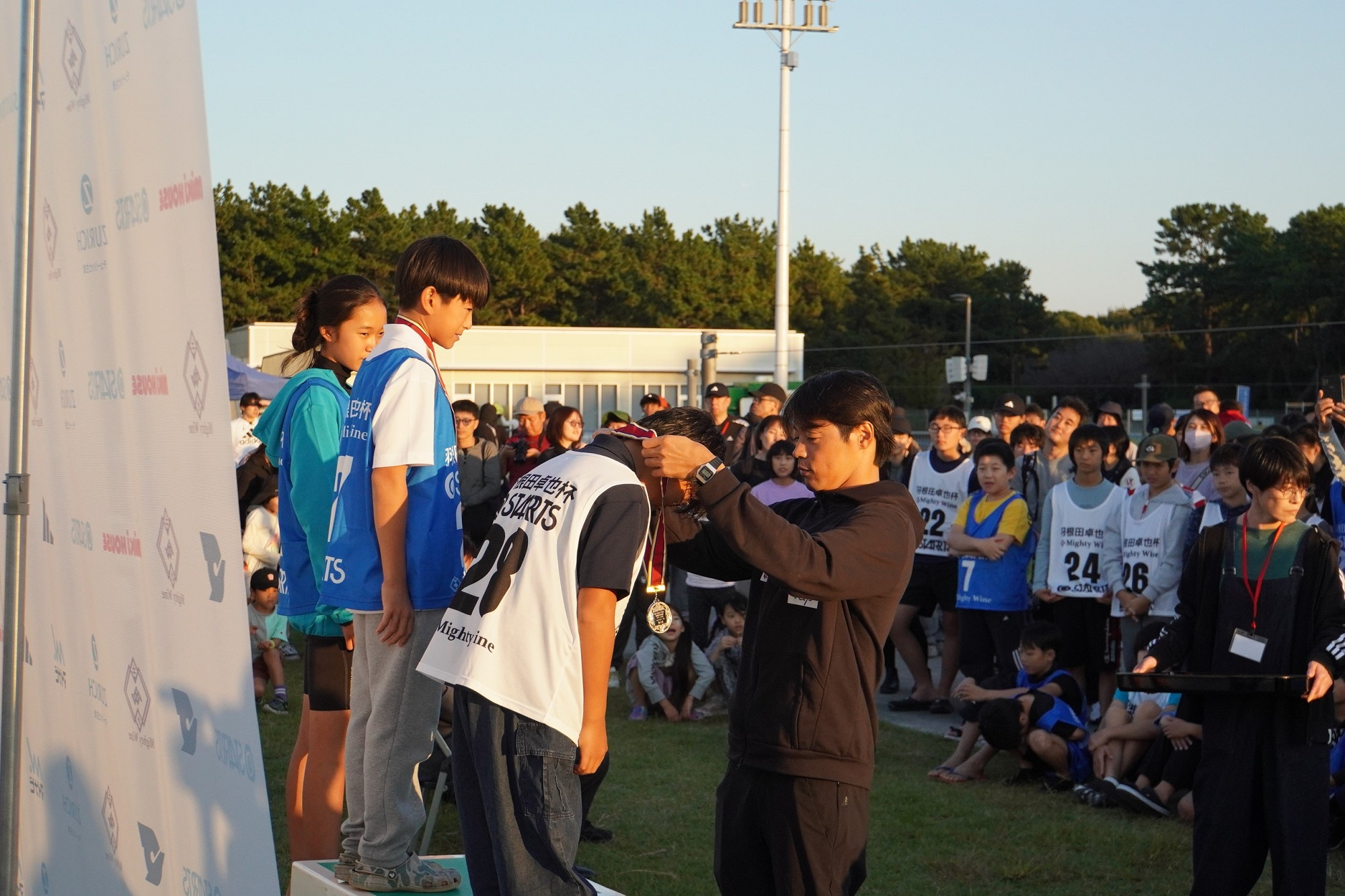 羽根田選手にメダルをかけられる参加者