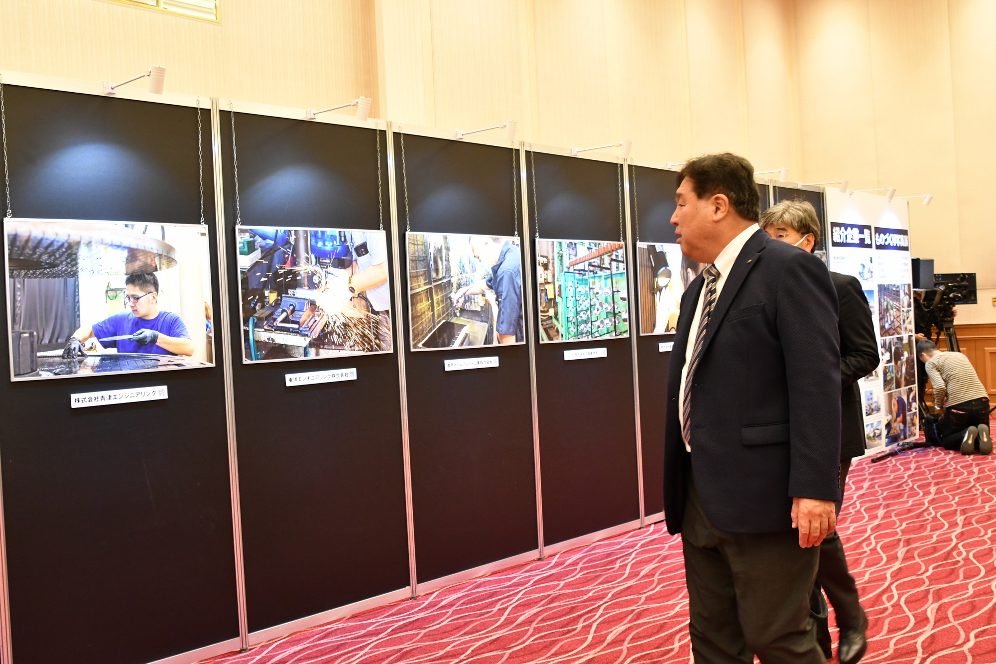 ものづくり企業の写真展を眺める区長