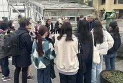 館長の解説を聴く皆さまと彫刻「蓮の子」