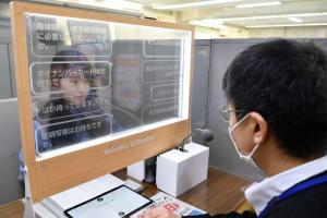透明翻訳ディスプレイ越しに喋る職員