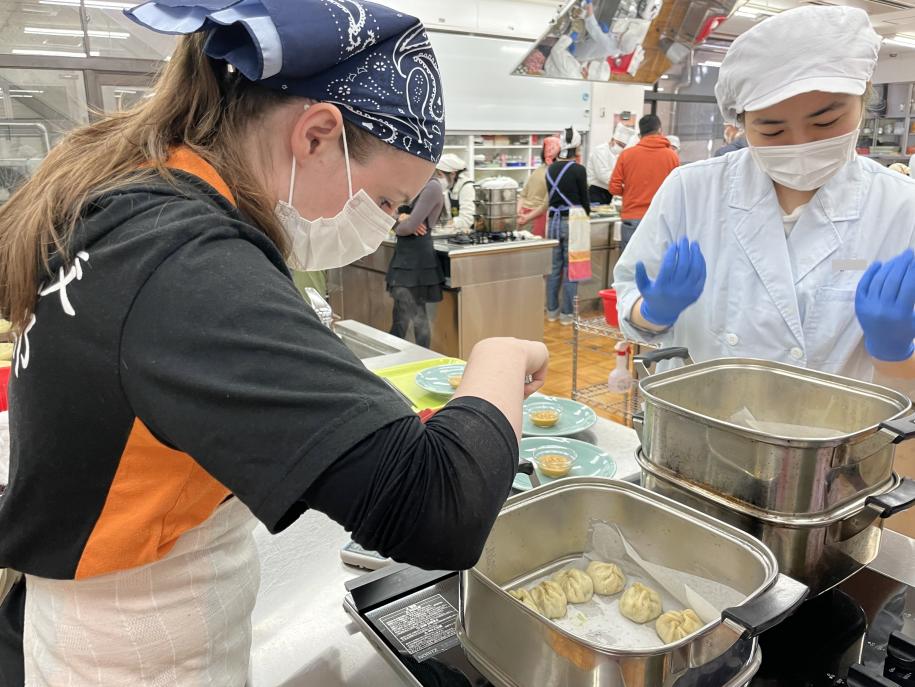 「モモ」を蒸す参加者と学生ボランティア