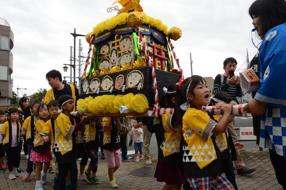 子どもたちが創作みこしを担いでいる区民