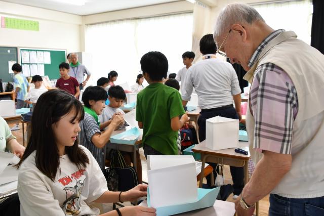 児童に灯籠づくりを教える江頭さん(旧中川灯籠流し実行委員会会長)