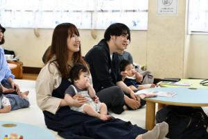 子どもを膝に乗せ音楽を楽しむ女性
