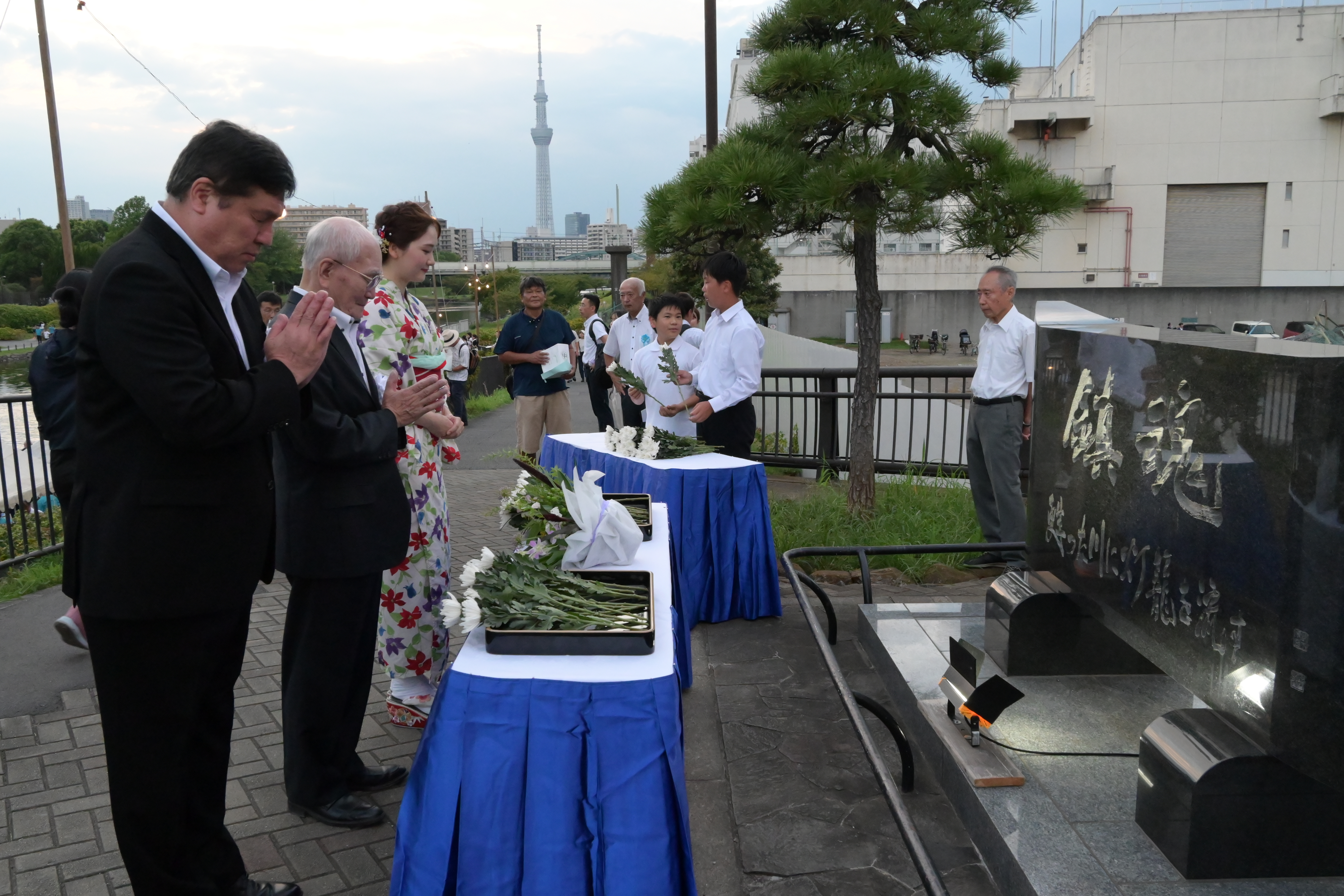 慰霊碑に手を合わせる区長
