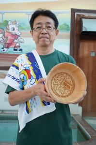 オリジナルグッズを持つ鴫原支部長