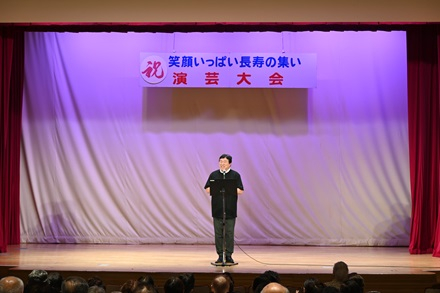 「笑顔いっぱい長寿の集い」演芸大会で話す斎藤区長