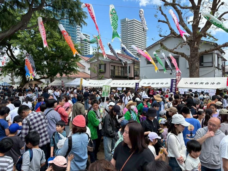 多くの人で賑わう会場と空を泳ぐ鯉のぼり