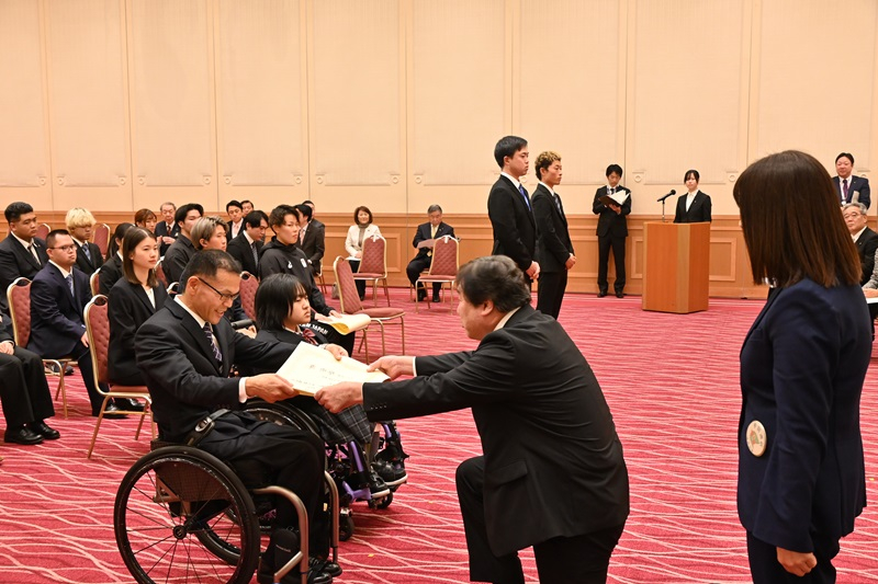 スポーツ栄誉賞顕彰式で受賞者に賞状を贈る区長2