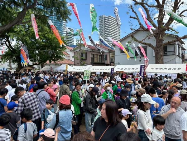 多くの人で賑わう会場と空を泳ぐ鯉のぼり