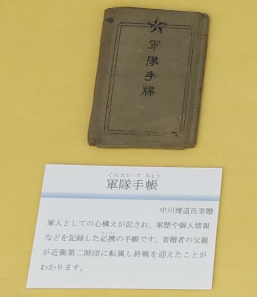 軍隊手帳　中川博道氏寄贈　陸軍の兵士が入営の際に貴重品を収めて携行した袋です。袋の裏面に「収容品」と書かれています。寄贈者の父親が出征の際に使用したものです。